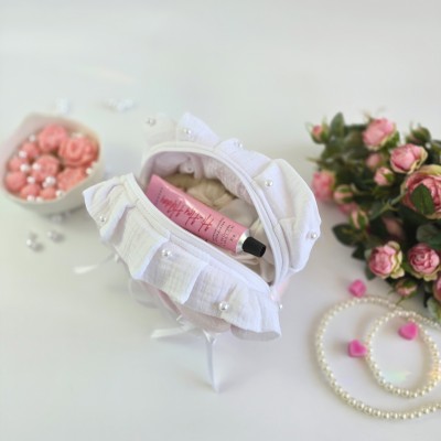 Small soft pink cosmetic bag with ruffles, bows and pearl-like beads