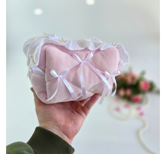 Small soft pink cosmetic bag with ruffles, bows and pearl-like beads